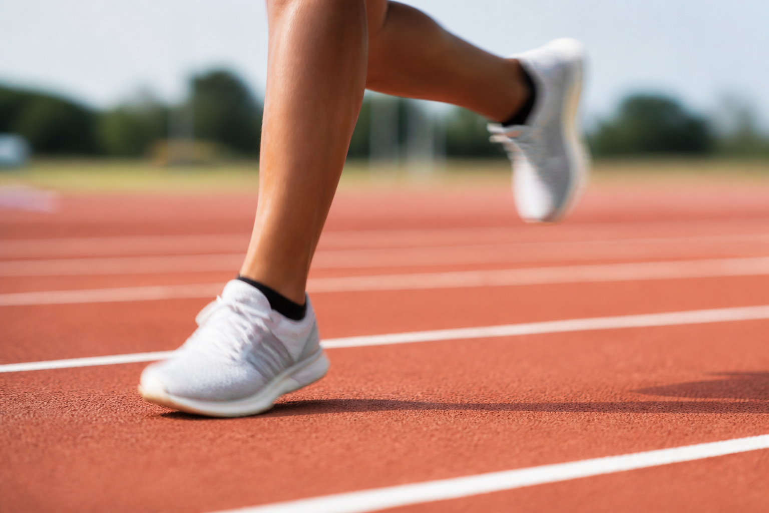 A close-up of a runner's feet in motion on a track, illustrating the concept of running pace.